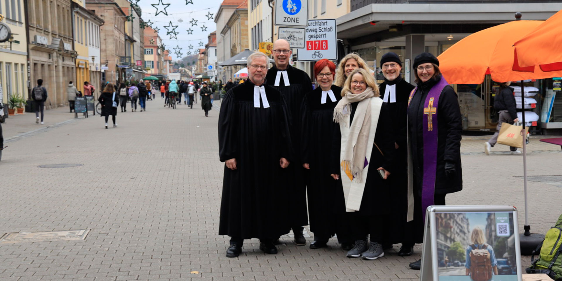 7 evangelischen Pfarrerinnen und Pfarrer aus Erlangen standen, weithin erkennbar im schwarzen Talar, zum Gespräch bereit. 