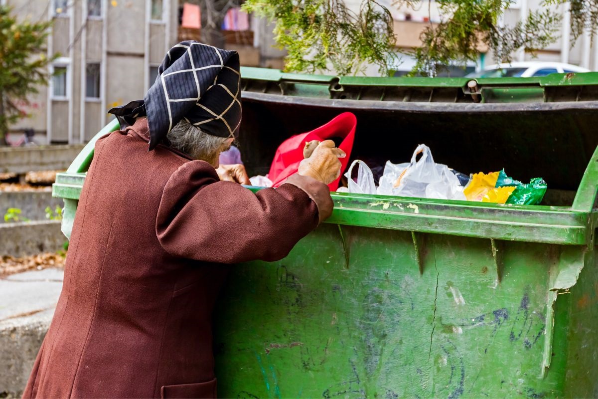 Symbolbild Frau beim Flaschensammeln am Container