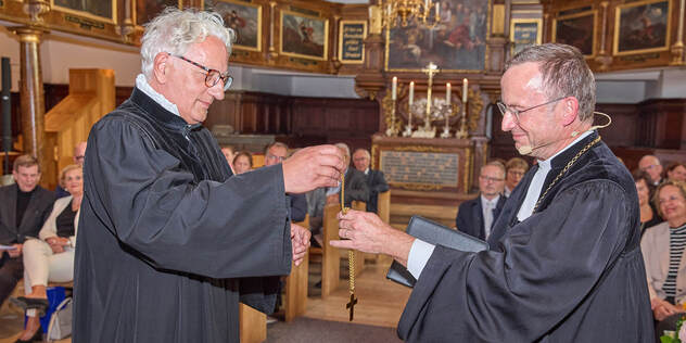 Regionalbischof Axel Piper gibt Landesbischof Christian Kopp sein Amtskreuz zurück.