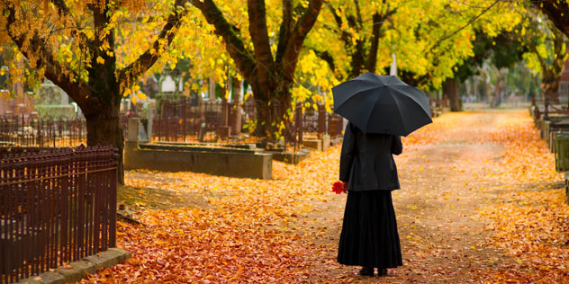 Trauernde Frau in herbstlichen Park