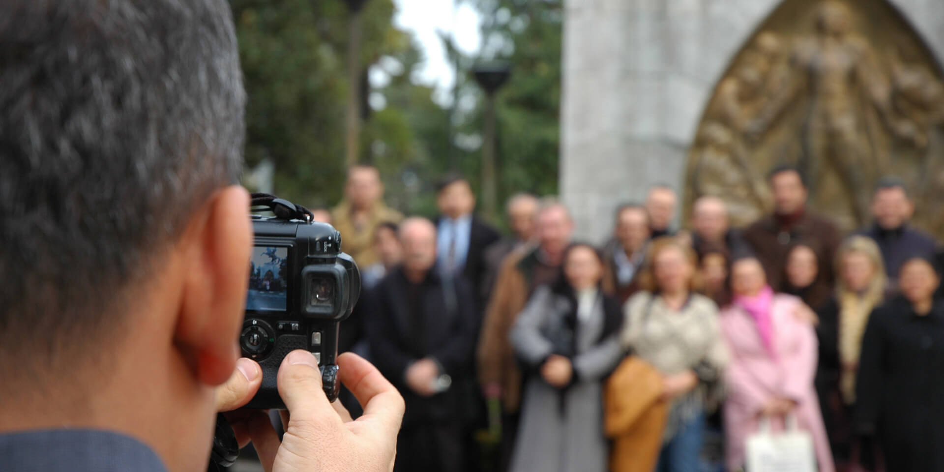 Das Bild zeigt eine Kirchengemeinde, die gerade vor einer Kirche fotografiert wird. Kirchengemeinde