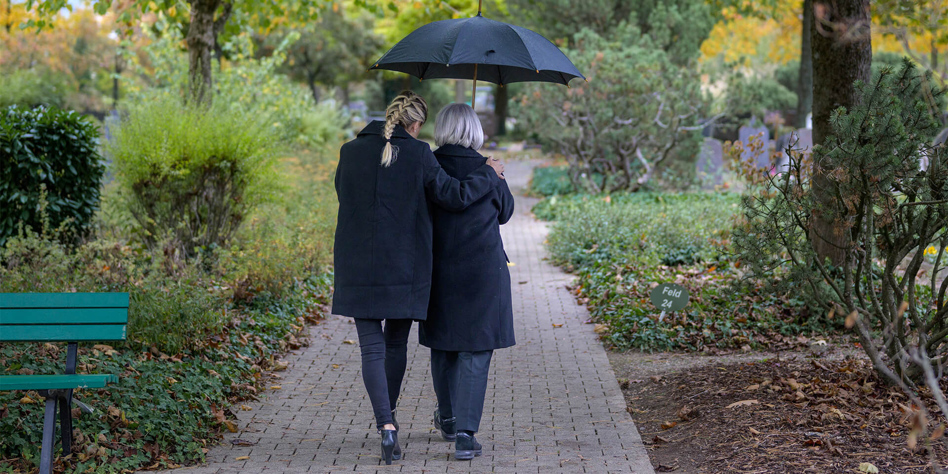 Zwei Frauen beim Gang über den Friedhof