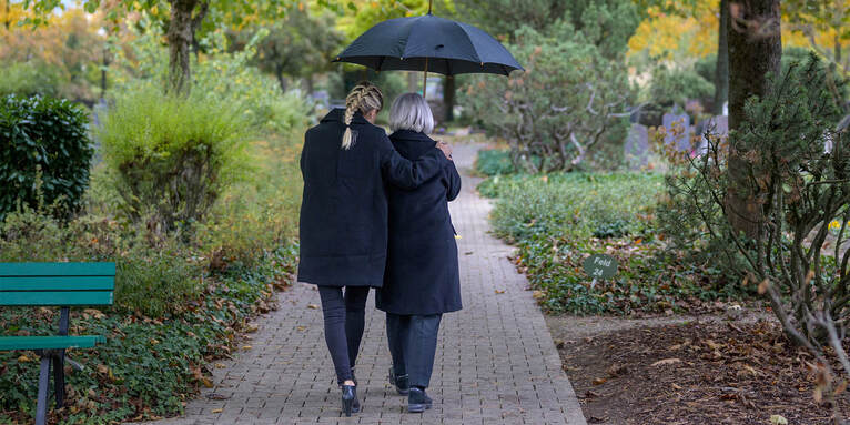 Zwei Frauen beim Gang über den Friedhof, © gettyimages/mheim3001