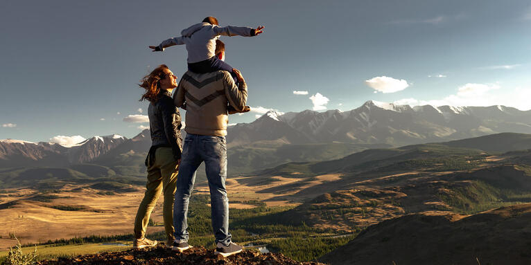 Eltern mit Kind vor Bergpanorama , © GettyImages-molchanovdmitry