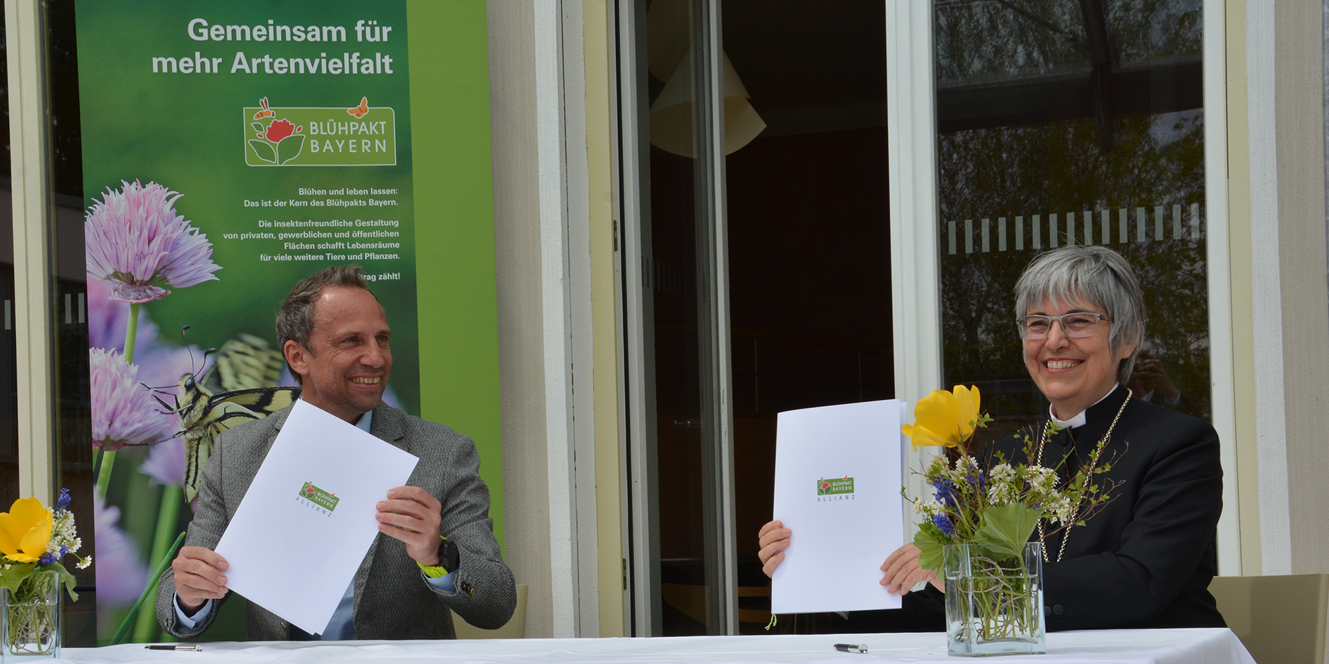 Der bayerische Umweltminister Thorsten Glauber und Regionalbischöfin Dorothea Greiner  bei der Unterzeichnung des Blühpakts