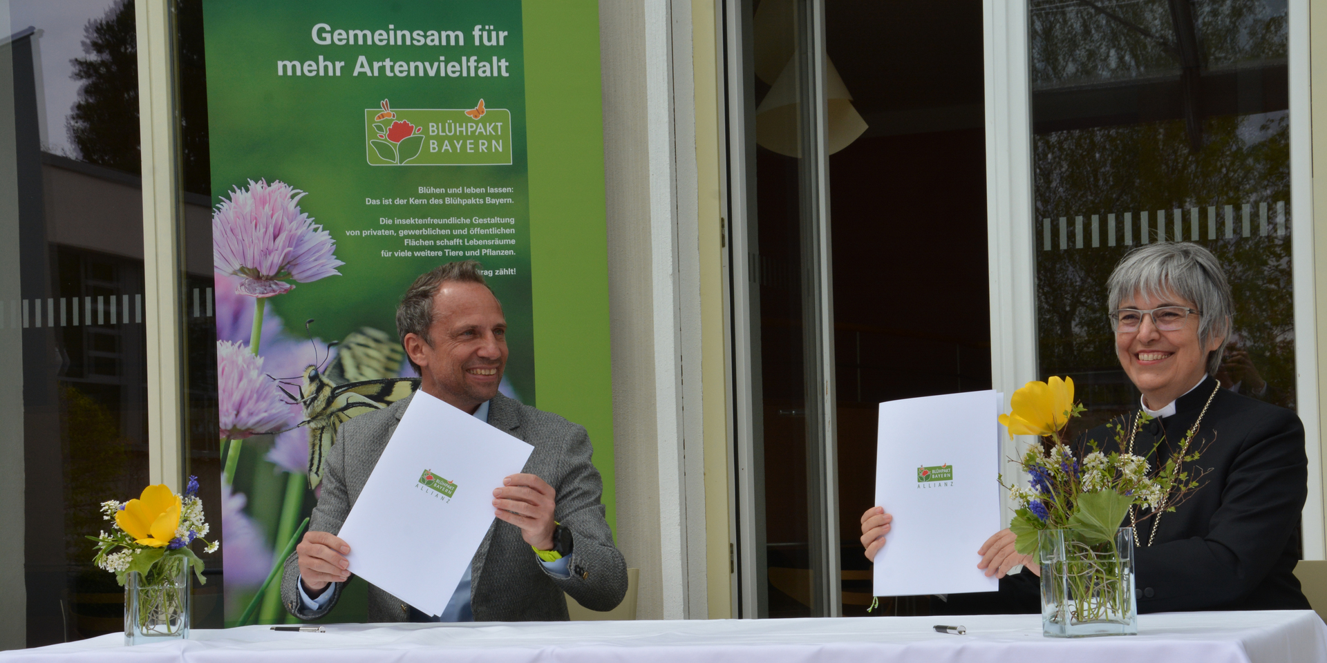 Der bayerische Umweltminister Thorsten Glauber und Regionalbischöfin Dorothea Greiner  bei der Unterzeichnung des Blühpakts