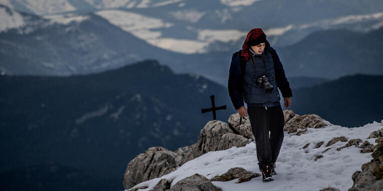 Mann am Gipfel im Schnee nachdenklich, © unsplash / Enrique Fernandez