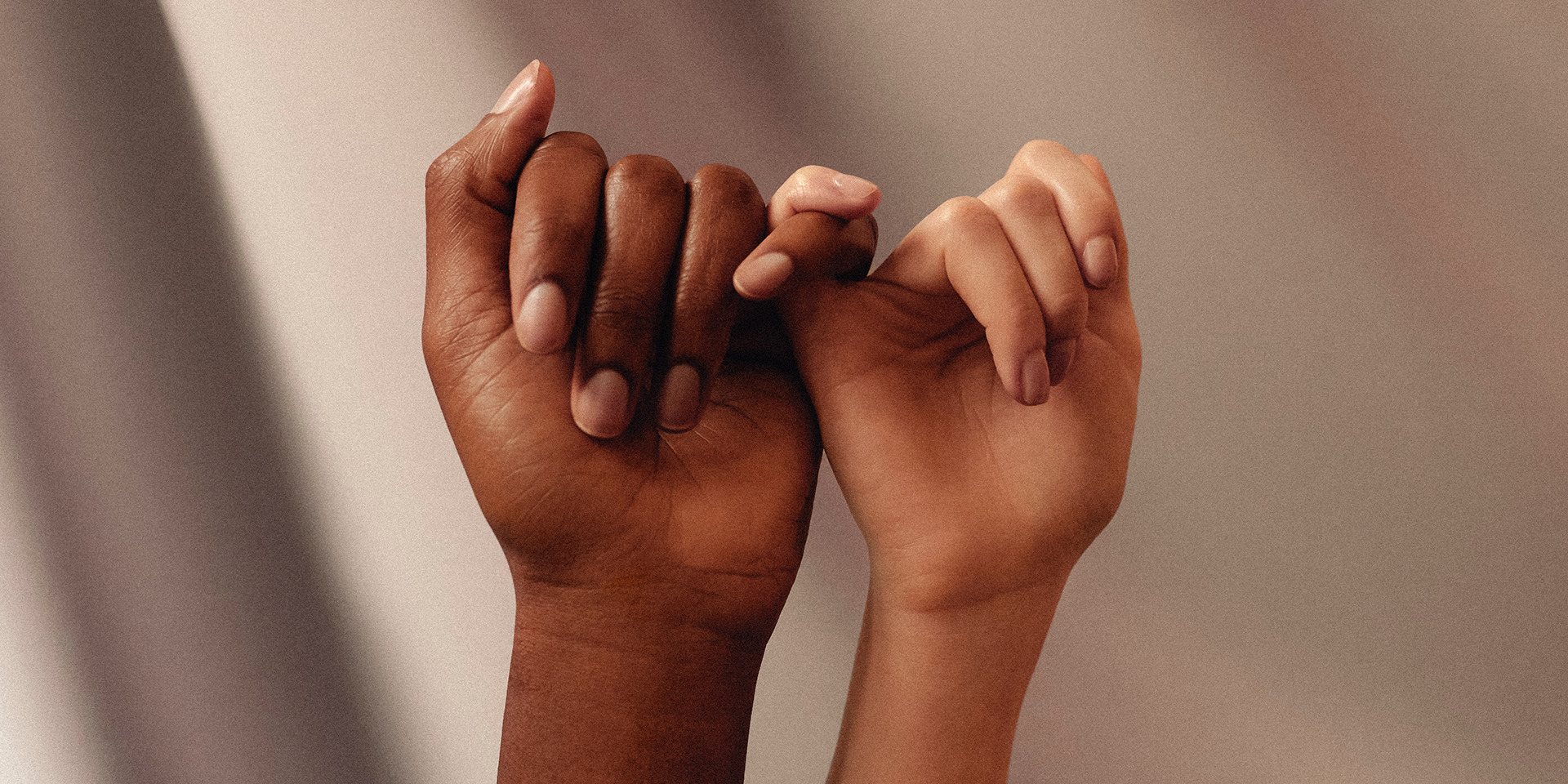 Zwei Hände unterschiedlicher Hautfarbe 