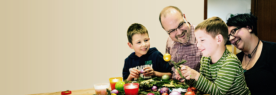 Gelebter Glaube Familie bastelt Adventskranz