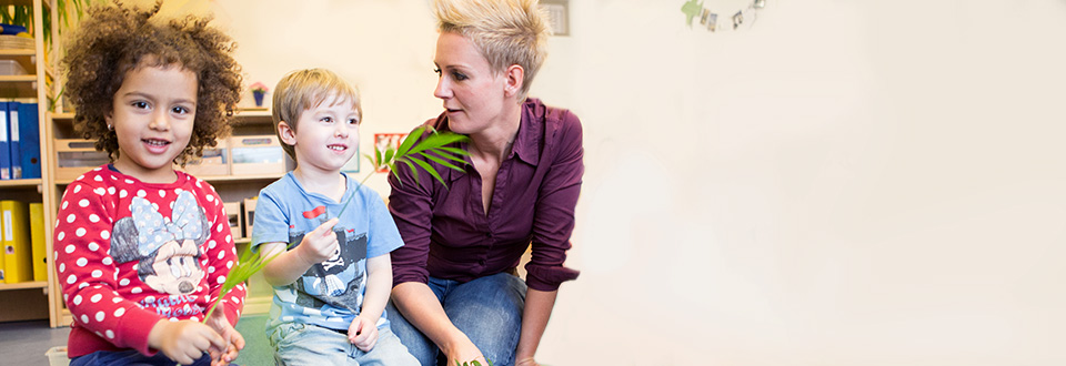 Gut behütet Kindergärtnerin mit Kindern