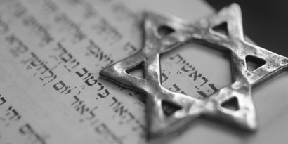 Das Bild zeigt einen eisernen Davidstern, der auf einem Blatt Papier mit hebräischen Schriftzeichen liegt.